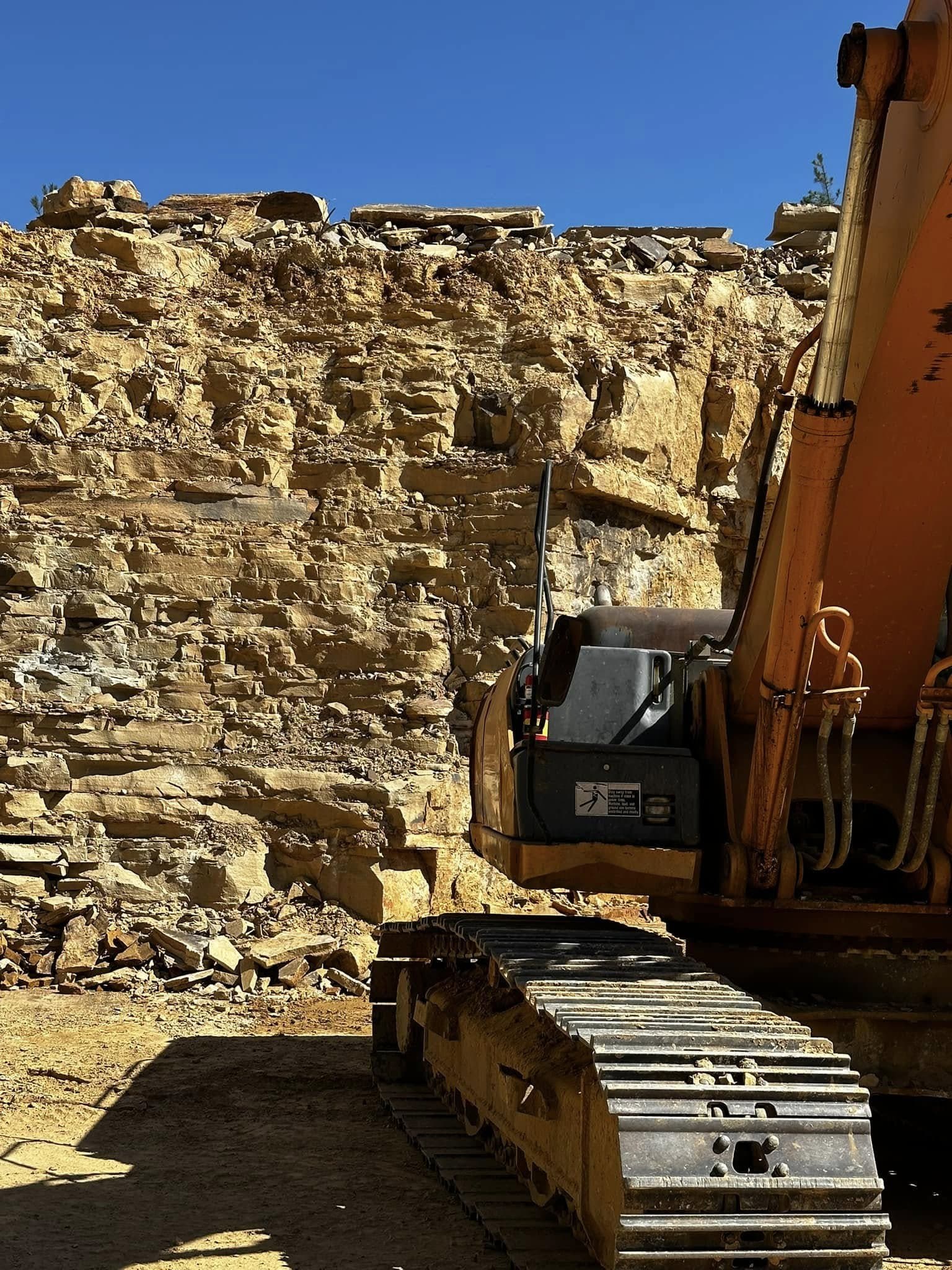 Excavator working an exposed Tennessee sandstone ledge at the Deer Creek Stone quarry